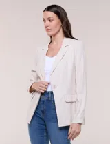 Blazer de silueta semientallada color beige, confeccionado en sastrería liviana de corte fluido, con solapa de muesca clásica, cierre frontal de un solo botón, bolsillos frontales con solapa y mangas largas.