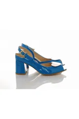 Sandalias de charol azul con taco ancho mediano, diseño peep toe y tira ajustable al talón con hebilla dorada. Incluyen un aplique removible en forma de corazón blanco en la parte delantera.