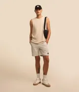 Musculosa básica para hombre de corte recto y cuello redondo, confeccionada en tejido de algodón. Presenta un diseño liso con un pequeño tag decorativo en el bajo.