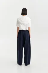 Pantalón ancho de tiro bajo color azul marino, con cintura elástica y cierre frontal de botones visibles.