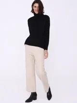 Pantalón ancho color beige con bolsillos laterales.