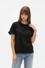 Remera negra de algodón, de corte ajustado, con cuello redondo y mangas cortas terminadas con volados.