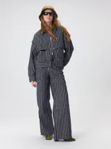 Pantalón de jean marrón de tiro medio, pierna ancha y estilo cargo con bolsillos utilitarios en las rodillas.