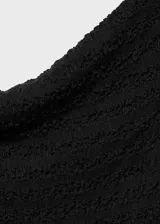 Vestido midi entallado de color negro, confeccionado en tejido con textura. Presenta cuello barco, diseño sin mangas y abertura posterior en el bajo.