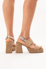 Sandalias de cuero color beige con plataforma, taco ancho y doble tira frontal. Cuentan con tira en el talón con hebilla metálica de ajuste.