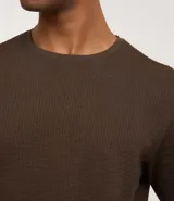 Remera de manga corta con cuello redondo, confeccionada en tejido tipo waffle con textura nido de abeja. Presenta un diseño liso y estructurado, ideal para un look casual y versátil.