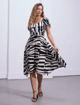 Vestido midi de rayón y lino con estampado geométrico en blanco y negro, escote cuadrado, mangas cortas con elástico y cintura elastizada.