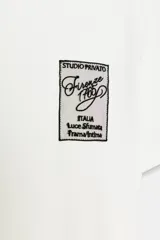 Camiseta blanca de manga corta y cuello redondo, con aplicación de organza y texto negro a contraste en el pecho.