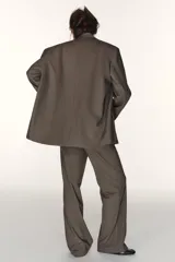 Blazer oversize de Zara con diseño a rayas verticales, cuello con solapa de muesca y hombreras. Presenta un cierre frontal cruzado con doble botonadura, bolsillos delanteros con solapa y un bolsillo de vivo en el pecho. Incluye forro interior a tono.