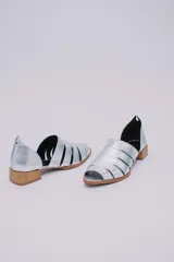 Sandalias de cuero negro con talón descubierto, tiras anchas entrecruzadas en el empeine y taco bajo de madera.