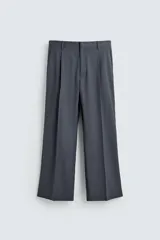 Pantalón de traje con corte flare fit, confeccionado en tejido con lana. Presenta diseño de tiro medio con pinzas frontales, bolsillos laterales y bolsillos traseros de vivo. Cierre frontal con cremallera y botón.