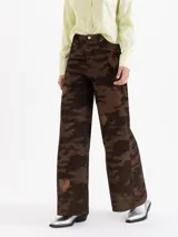 Pantalón de corderoy de algodón con silueta wide leg y tiro alto. Presenta un diseño de estampado camuflado con detalles de corazones bordados distribuidos en la prenda.