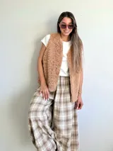 Pantalón de corte amplio y holgado, confeccionado en franela con estampado de tartán escocés en tonos azul, negro y beige. Presenta cintura elástica para un ajuste cómodo.