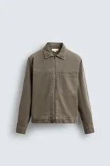 Sobrecamisa de hombre de corte relajado, confeccionada en denim de algodón color verde oliva. Presenta cuello solapa, manga larga con puño abotonado, bolsillo plastrón en el pecho y cierre frontal con cremallera.