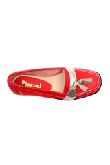 Mocasín de cuero negro con detalle de antifaz plateado y borlas.