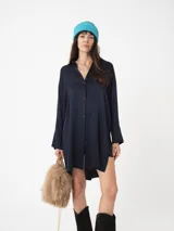 Camisa amplia color blanco, de textura arrugada, con laterales abiertos y detalle de tabla en la espalda.