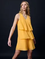 Vestido corto de gasa color amarillo, con escote en V, sin mangas y forro interno a tono.