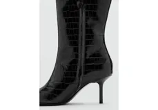 Botas altas de caña media con acabado texturizado tipo cocodrilo, punta fina y tacón de aguja. Diseño elegante con cierre lateral.