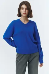 Sweater de tejido de punto color azul eléctrico, con escote en V y mangas largas. Presenta terminaciones elásticas en puños y bajo.