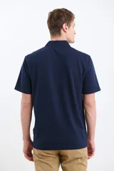 Remera verde con cuello polo y tapeta de dos botones. Corte clásico y mangas cortas.