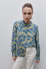 Camisa de calce amplio y fluido de viscosa liviana, con estampado de rayas verticales irregulares en blanco y negro, cuello mao, abotonadura frontal y mangas largas.