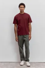 Pantalon de corte recto en color verde oliva, confeccionado en tejido de algodón con acabado ligeramente desgastado, cuenta con bolsillos laterales y cierre frontal.