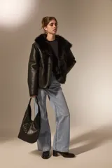 Bolso tipo hobo de gran tamaño, color negro, con diseño trenzado en la parte frontal y base lisa. Cuenta con un asa integrada para llevar al hombro.