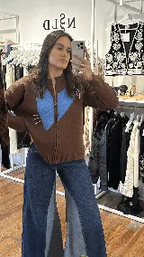 Campera tejida de hilo con cierre frontal, diseño en color marrón chocolate con un gran corazón azul en el frente y detalles bordados. Posee cuello, puños y ruedo acanalados.