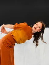 Blusa color ocre de algodón tipo seda, teñida a mano con técnica tie dye. Tiene corte recto, cierre invisible en el escote delantero y mangas regulables con elástico.