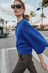 Jersey de punto liso color azul, con cuello redondo, botones delanteros y manga ancha por debajo del codo.