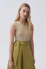 Top corto de lurex color dorado, sin mangas y con cuello a la base.