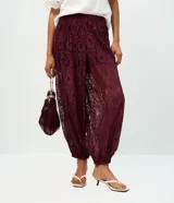 Pantalón aladín de encaje floral bordó, de calce amplio con cintura elástica y puños ajustados en los tobillos.