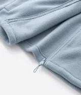 Buzo de fleece color verde agua con capucha ajustable, cierre frontal completo y bolsillo con cierre en el pecho. Presenta un diseño funcional con recortes en tejido plano y calce regular.