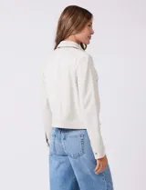 Chaqueta color beige de símil gamuza, con cuello solapa, cierre frontal y bolsillos aplicados en el pecho. Puños con botón a presión.