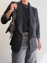 Blazer sastrero de corte clásico con solapas frontales, mangas largas con puños vueltos y bolsillos laterales con solapa. Confeccionado en tela con caída, cuenta con forro interior completo.