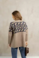 Saco tejido de punto con diseño de guarda inca en la parte superior. Presenta bolsillos frontales con detalles de tiras de cuero y flecos. De corte recto y largo medio, con terminaciones en tejido acanalado.