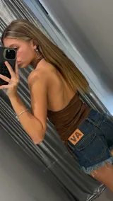 Top marrón de escote halter con breteles anchos y ajuste lateral mediante cordones. Confeccionado en tejido elástico, presenta un diseño ajustado al cuerpo.