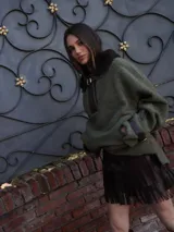 Buzo color crudo con cuello de piel sintética color crema, abertura parcial con cierre de cuero marrón y hebilla dorada, puños con ajuste de cuero marrón y bolsillos laterales.