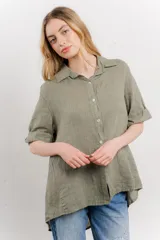 Camisa de lino color verde militar, de corte amplio y caída ligera. Cuenta con cuello camisero, botones en el frente y mangas 3/4 que se pueden arremangar.