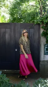 Falda midi evasé de raso color negro, con cintura elástica y cinturón con apliques metálicos.