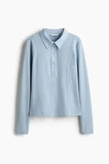 Remera polo de manga larga en punto de algodón, con cuello clásico, tapeta con botones y costuras moldeadoras en el frente.