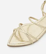 Sandalia plana plateada de material sintético, con puntera en forma de hoja y tiras finas con hebilla.