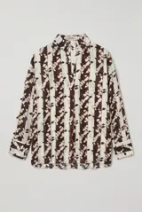 Blusa estampada en tonos marrón y crudo, de corte holgado, con cuello camisero, escote en V y mangas largas.