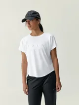 Remera deportiva blanca de manga corta y cuello redondo, confeccionada en poliéster y elastano, con estampa sutil en el pecho.