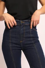Jean de tiro alto en color negro, con diseño de pierna semi Oxford. Presenta recortes verticales y pespuntes visibles en la parte delantera que estilizan la silueta.