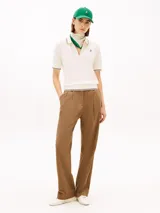 Chomba de piqué color blanco de Tommy Hilfiger, con mezcla de algodón elástico y lyocell. Presenta manga corta, cuello camisero con cierre frontal de cremallera y detalles de líneas oscuras en cuello, puños y dobladillo. Incluye logo bordado en el pecho.