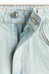 Short denim de cinco bolsillos confeccionado en algodón rígido, con diseño de tiro súper alto, detalles de roturas y desgastes, cierre frontal con botón y terminaciones deshilachadas.