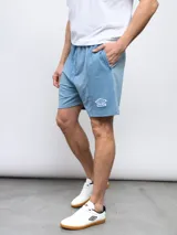 Bermuda de felpa negra con efecto lavado, corte recto y cordón ajustable en la cintura. Presenta un panel vertical en la parte delantera de cada pierna y el logo Umbro bordado en blanco en el muslo izquierdo.