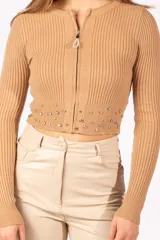 Cardigan de punto acanalado color tostado, con cierre frontal completo y detalle de strass en el ruedo.