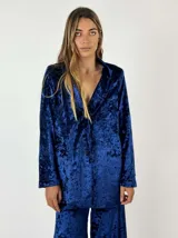 Blazer gris de terciopelo con solapas y cierre frontal con un botón. Presenta un patrón de matices sutiles en la tela.